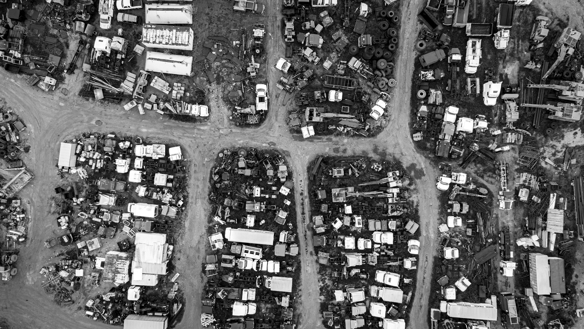 A black and white aerial view of a car savage yard.
